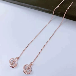Detail of rose gold threader earrings featuring a hollow sphere with crystal insert