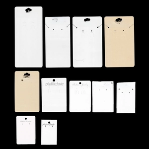 Various sizes of white and kraft paper jewelry display cards for earrings and necklaces