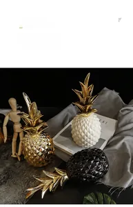 Close-up of modern geometric pineapple ceramic ornaments in gold, black and white