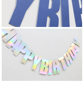 Detail of holographic paper Happy Birthday banner showing iridescent finish and blue letters