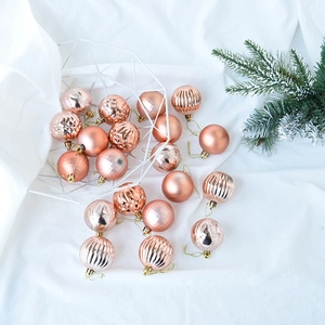 Detailed view of rose gold Christmas balls with matte and textured finishes in a basket