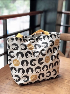 Détail d'un sac à lunch en toile avec motif ours polaire et poignées jaunes