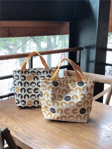Vue détaillée des sacs à déjeuner en toile à motif d'ours polaire sur une table en bois