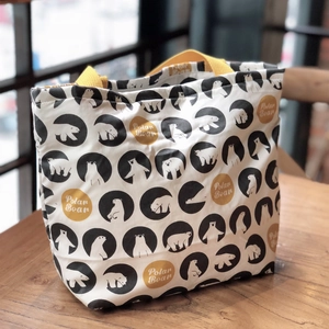 Gros plan du sac à lunch en toile blanche avec motif ours polaire et anses jaunes