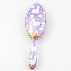 Detail of purple hairbrush featuring alpaca patterns and flowing glitter in a clear shell