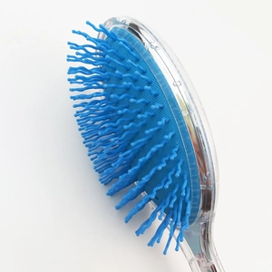 Macro detail of blue wavy bristles on a transparent glitter hairbrush with air cushion