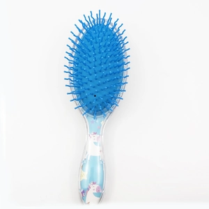 Detail view of cartoon unicorn pattern and blue nylon bristles on a sequined hairbrush