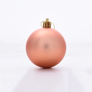 Detailed view of a matte rose gold Christmas ball ornament with a gold hanging string