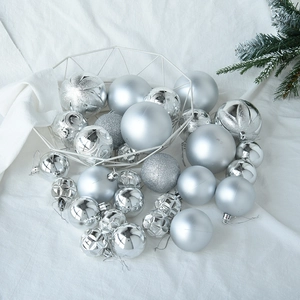 Detailed view of silver Christmas ornaments with matte and glitter finishes in a white basket