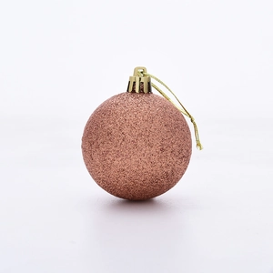 Close-up of a rose gold glitter Christmas ball ornament with a golden hanging string