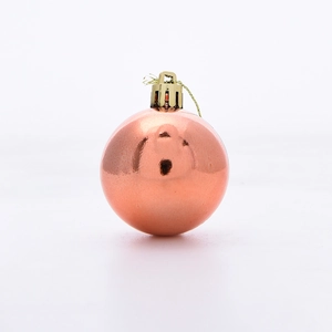 Detailed view of rose gold metallic Christmas ball with golden hanging loop for tree decor