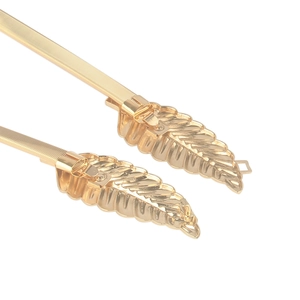 Detail of gold elastic leaf belt with intricate hollowed metal leaf buckle for dresses