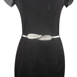 Macro shot of silver leaf buckle on metallic elastic belt over a black sequin dress