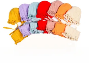 Detail of colorful knit baby hats featuring braided patterns and scalloped brims in various colors