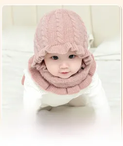Close-up of baby winter knit hat and scarf set with ruffled edges in warm lotus pink