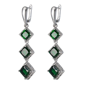 Detail of elegant silver drop earrings with three square green cubic zirconia stones