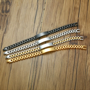 Detail of four stainless steel link bracelets in black silver and gold on wood surface