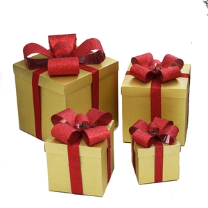 Set of four nesting gold gift boxes with sparkling red glitter bows for holiday decor
