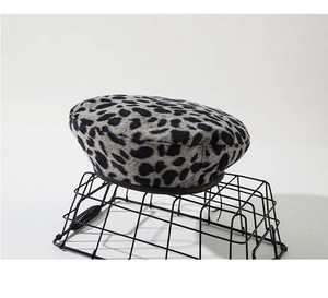 Close-up of leopard print wool beret fabric texture on a mesh display stand
