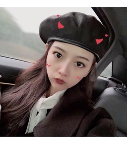 Classic black wool beret with leather trim shown on a model inside a car interior