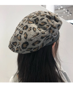 Close-up of leopard print wool beret hat showing texture and grey brown spotted pattern