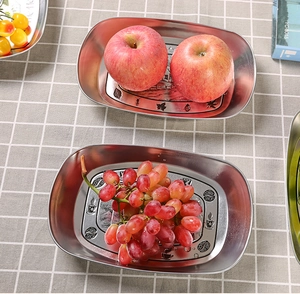 Close-up of vintage tinplate tray with coffee patterns holding fresh red apples and grapes