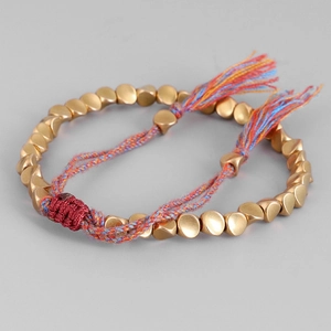 Pulsera bohemia tejida a mano con cuentas doradas irregulares y borlas de colores