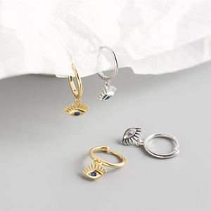 Close-up of S925 sterling silver evil eye earrings with blue zircon in gold and silver