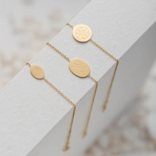 Detailed close-up of three gold-plated 304 stainless steel chain bracelets with charms