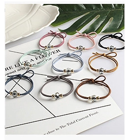 Detail of colorful elastic hair ties set with faceted clear beads and gold accents