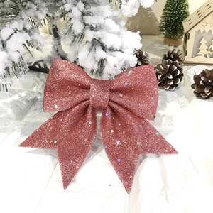 Gros plan d'un nœud de Noël rose pailleté montrant une texture et détails étincelants