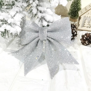 Gros plan détaillé montrant la texture pailletée argentée d'un nœud de Noël décoratif