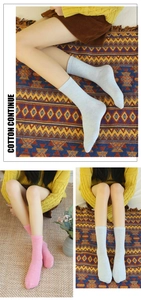 Detail of light blue and pink cotton crew socks with knitted texture on a warm rug