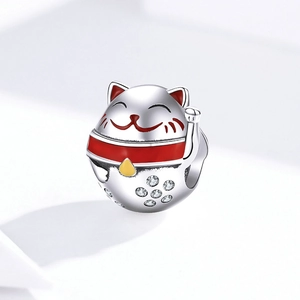 Detailed close-up of lucky cat charm with red enamel and white zircon stones