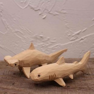 Détail de deux figurines de requins en bois faites à la main montrant le grain naturel