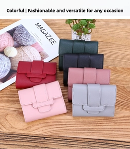 Flat lay of multiple colorful PU leather tri-fold wallets on a wooden surface