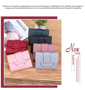 Detail showing various colors of slim tri-fold minimalist wallets on a wooden surface