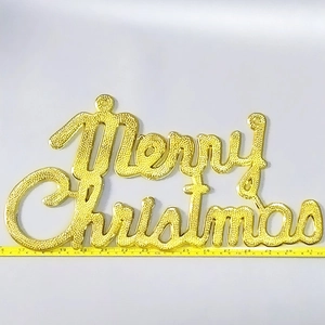 Detailed view of golden Merry Christmas decorative sign with embossed texture on white background