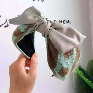 Detail showing texture of knitted wide headband with large satin bow decoration