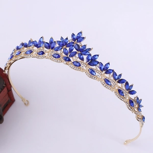 Close-up of golden bridal crown featuring elegant blue leaf-shaped crystals and small diamonds