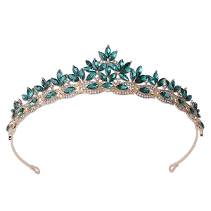 Detail of vintage gold crown featuring green marquise crystals and fine white rhinestones