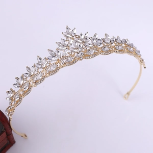 Detailed macro of golden bridal crown featuring crystal leaf patterns and floral motifs