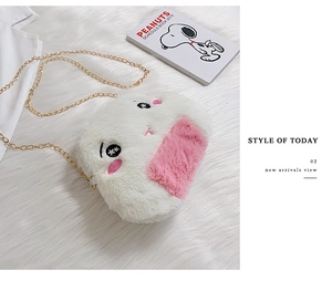 Detail of plush heart bag with cute cartoon embroidery and gold metal chain strap
