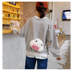 Detail of cute rice ball plush crossbody bag with pink accents and metal chain strap