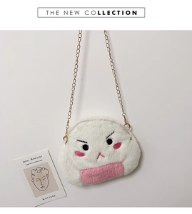 Detail view of plush cartoon rice ball bag with pink base and gold chain strap