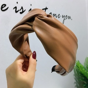 Gros plan d'un serre-tête torsadé en cuir PU marron porté pour un style tendance