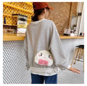 Close-up of a cute plush rice ball crossbody bag with embroidery on a model