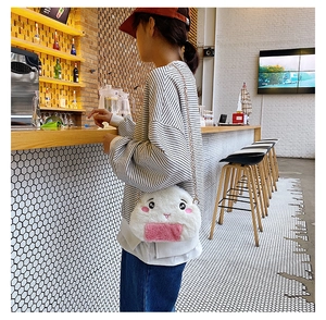 Detail of plush rice ball crossbody bag featuring pink embroidery and a gold chain strap