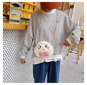 Detail of cute white plush rice ball bag with gold chain strap worn by a model