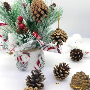 Détail de pommes de pin naturelles avec cordon doré pour décoration de sapin de Noël